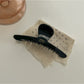 Beau chic acetate claw clip shown from the bottom to display hinge details