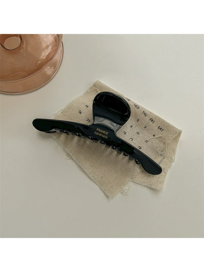 Beau chic acetate claw clip shown from the bottom to display hinge details