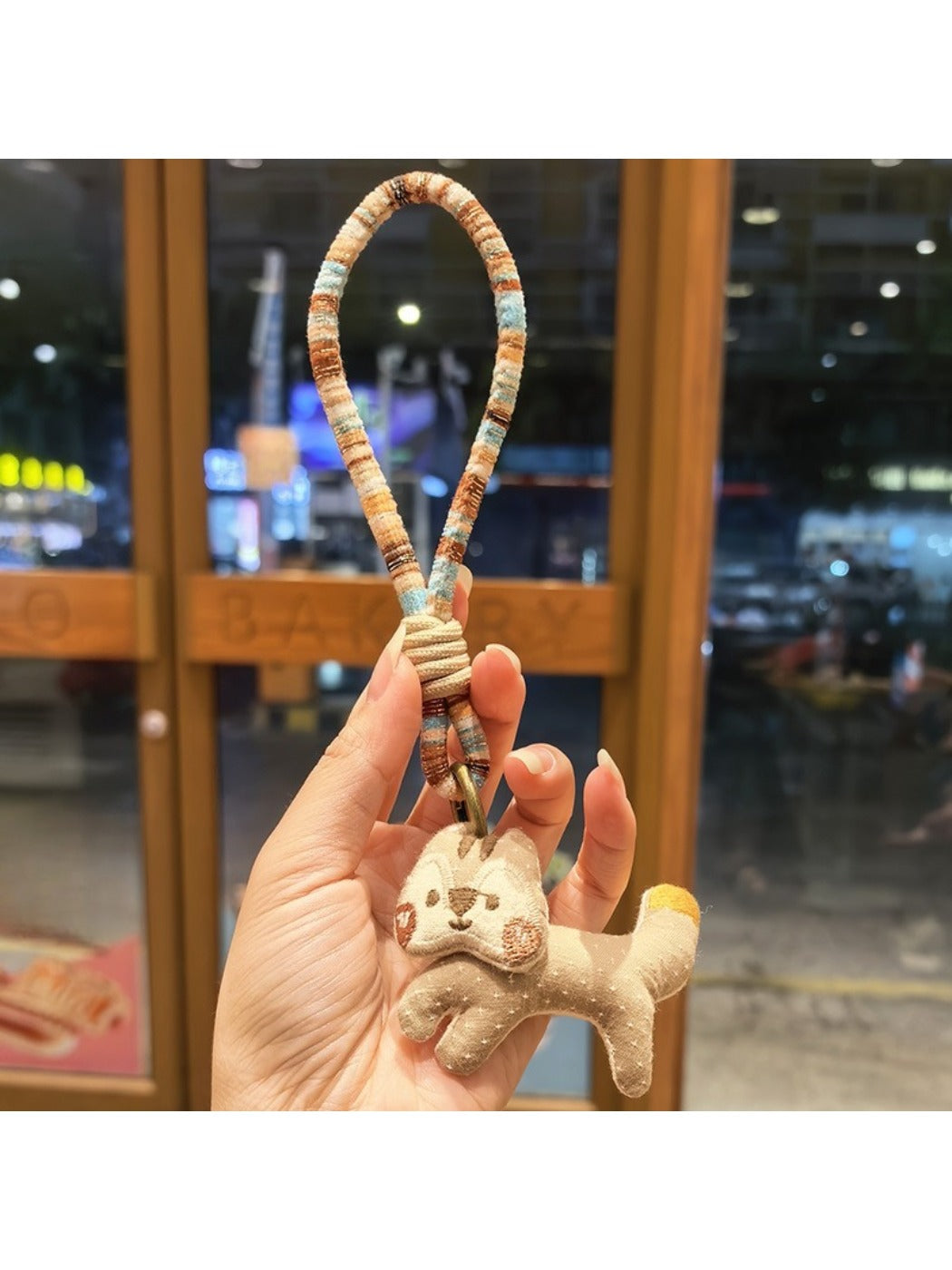 Keypus squirrel charm keychain hanging from a backpack zipper pull