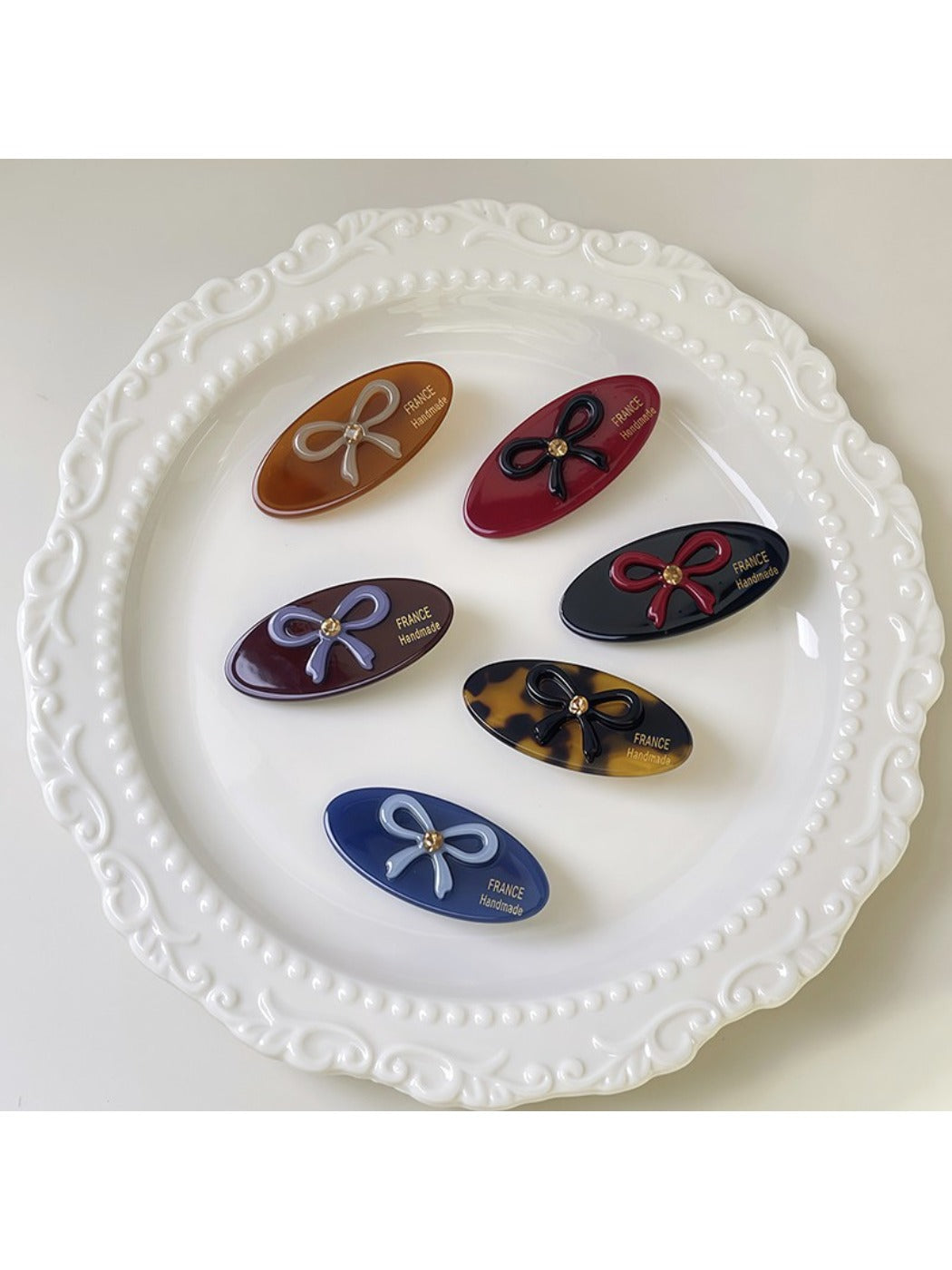 Close-up of beige oval butterfly hair clip showing smooth matte finish