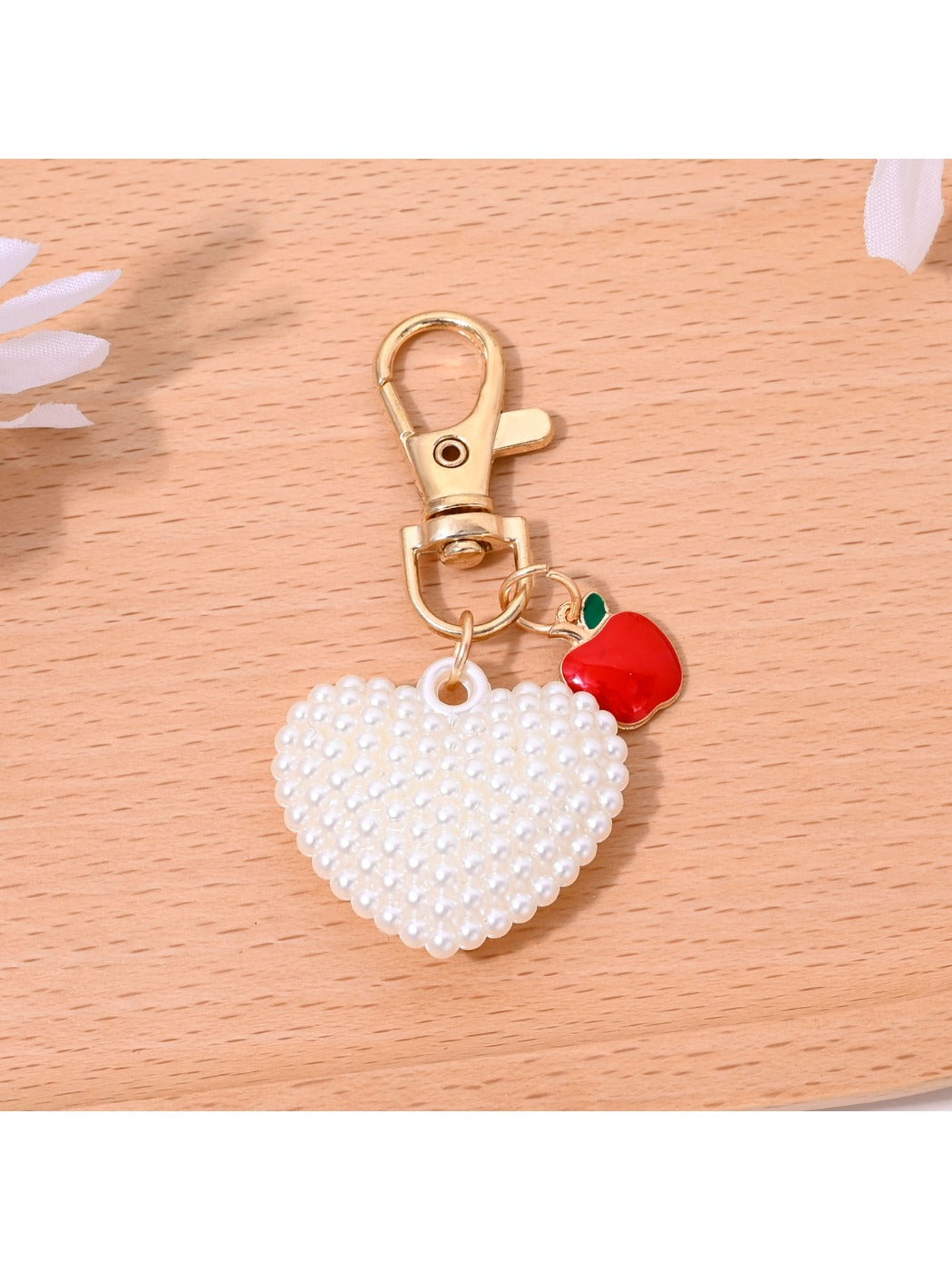 Heart shaped bag charm keychain displayed alongside matching red leather wallet