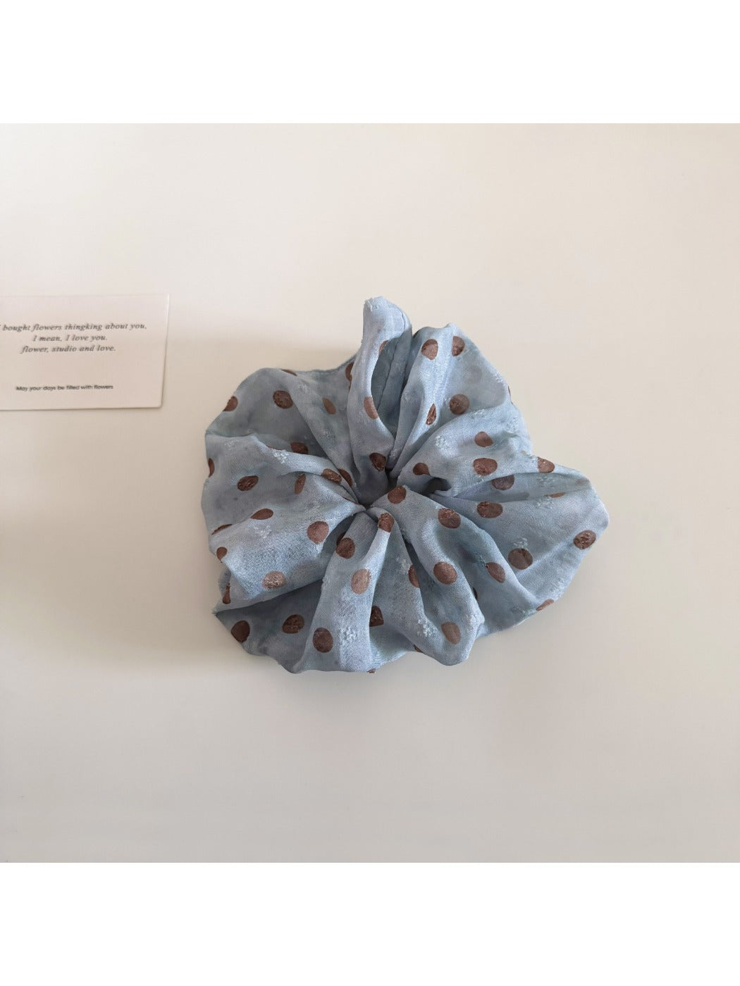 Gifty scrunchie worn on a wrist showing size and pattern