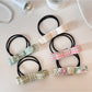 Close-up of a cute hair tie with a pink bow embellishment on a white background