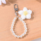 Top view of a multicolored yarn flower keychain with small beads attached to a keyring