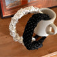 Close-up of Gifty pleated polka dot headband showing fabric texture and pleats
