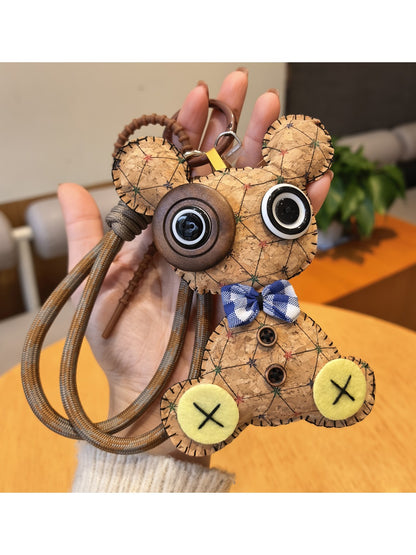 Vintage little bear keychain placed next to a notebook and pen on a desk