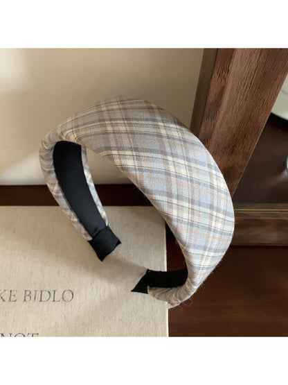 Wide plaid headband styled with a winter coat and scarf on a model