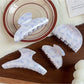 Close-up of Beau hair claw clip with blue floral pattern and curved teeth