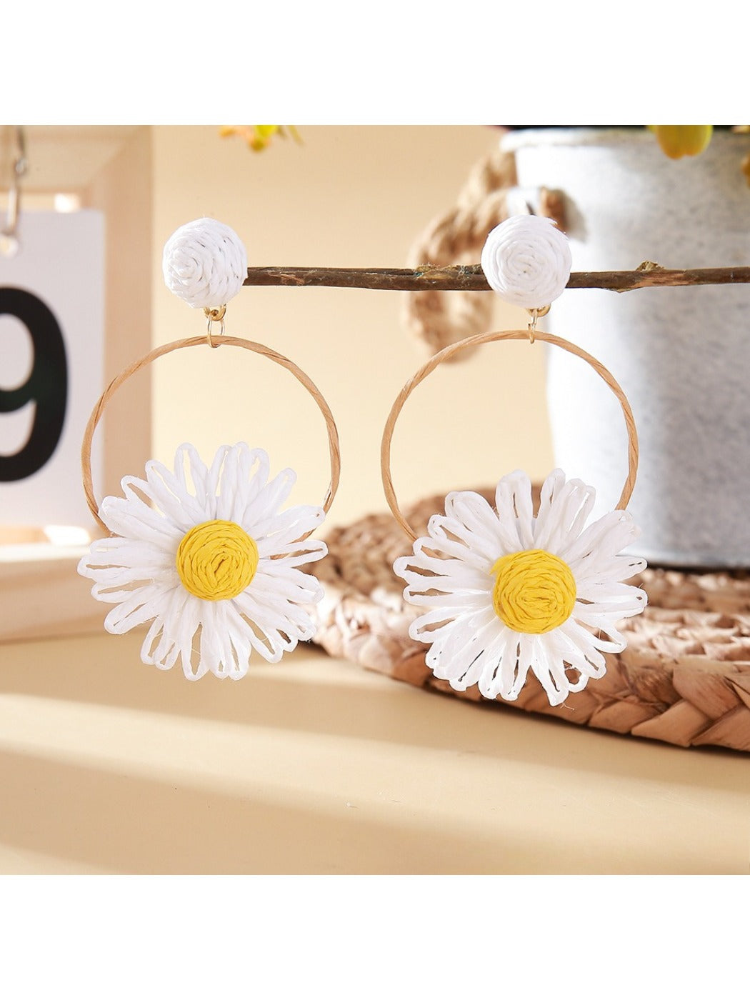 Earedge woven raffia circle flower earrings displayed on a wooden surface