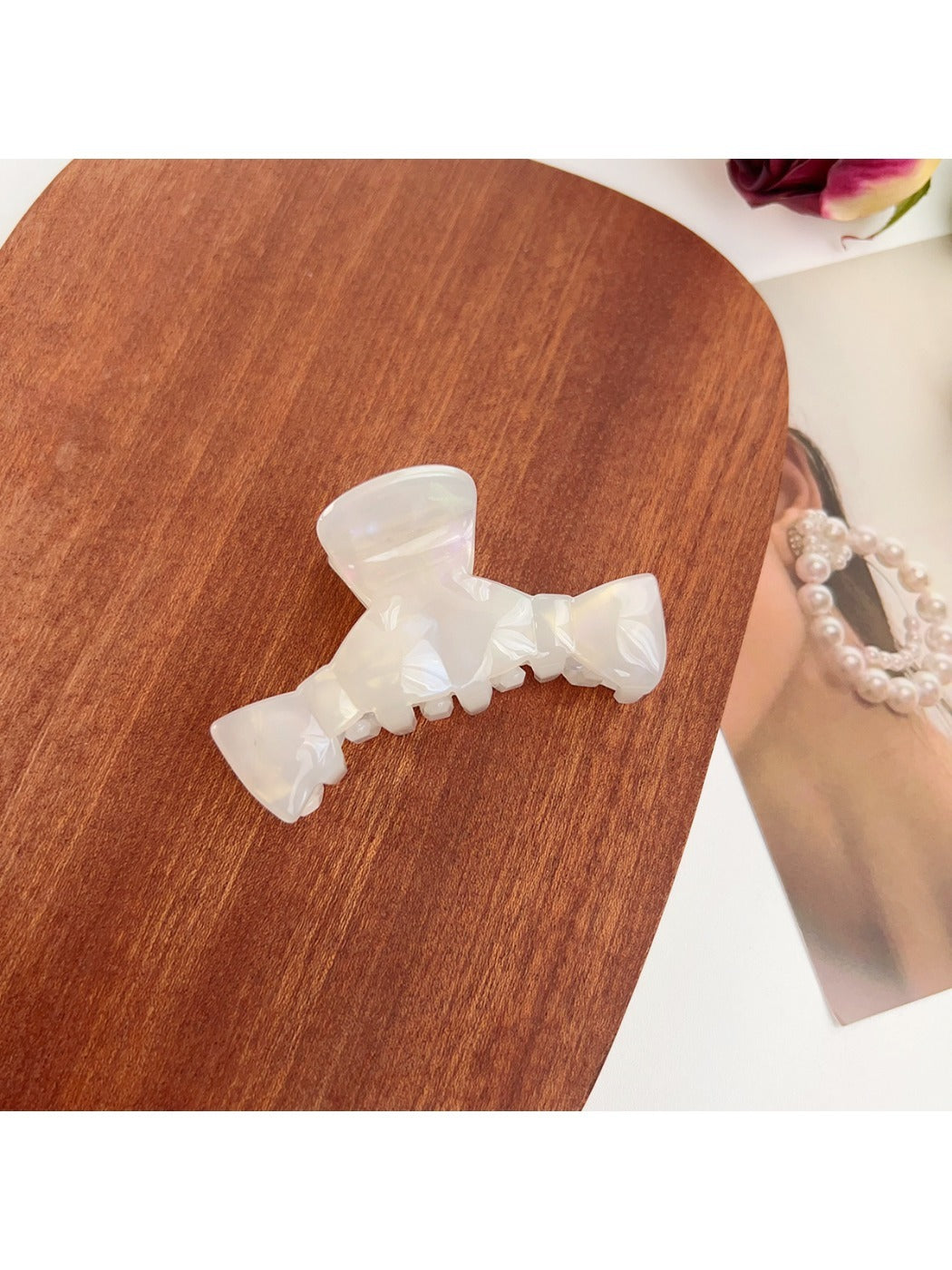 Beau minimalist bow shaped claw clip displayed with soft shadows