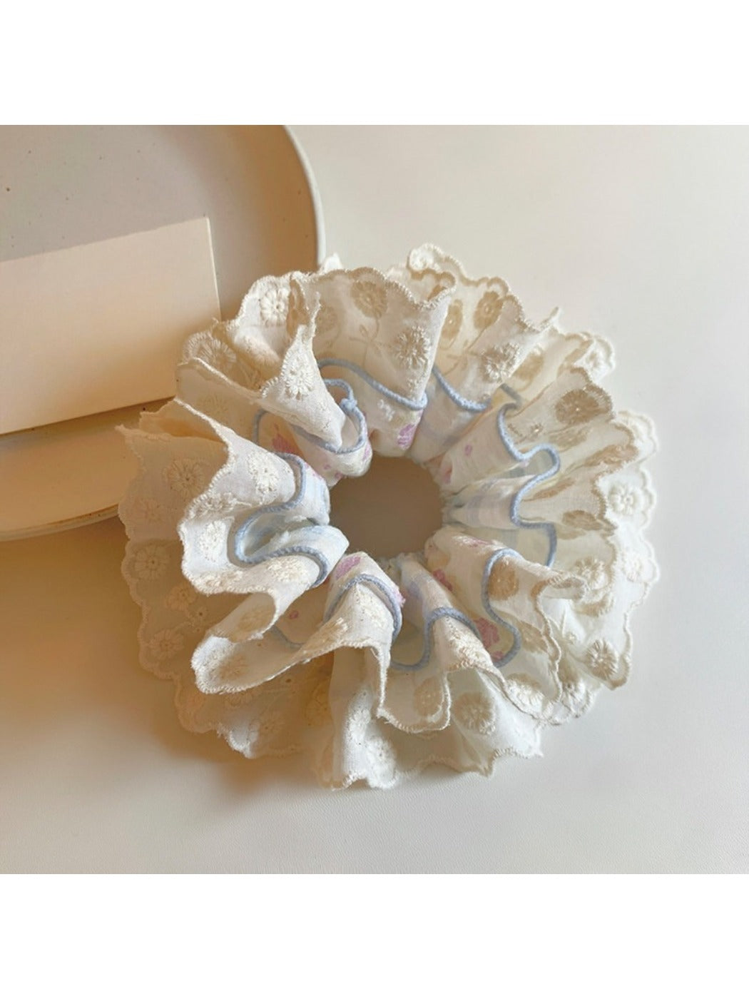 Close-up of blue lace fabric on double scrunchie showing texture and detail