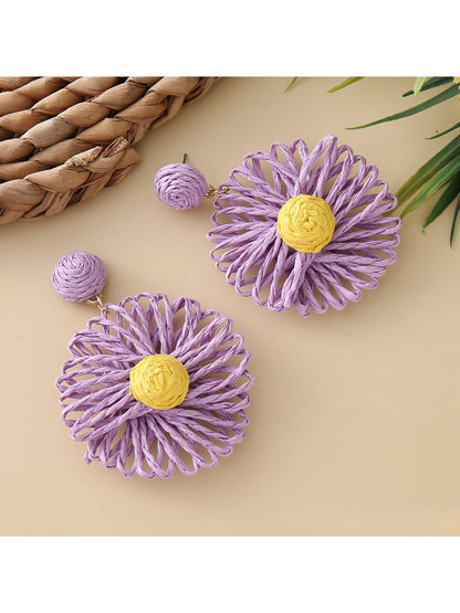 Model wearing raffia sunflower earrings with casual outfit and natural makeup