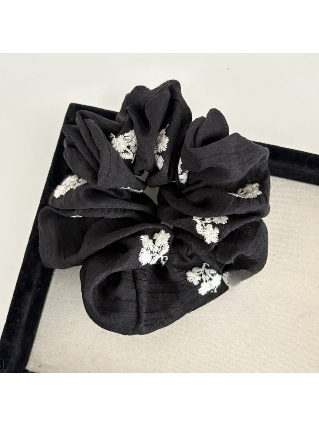Gifty scrunchie worn on a wrist showcasing its size and floral pattern