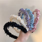 Close-up of Gifty sleek minimalist twist headband in black fabric