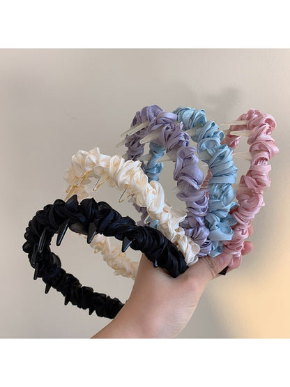Close-up of Gifty sleek minimalist twist headband in black fabric