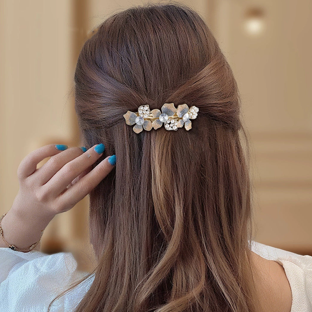 Gold-tone floral branch barrette worn in hair