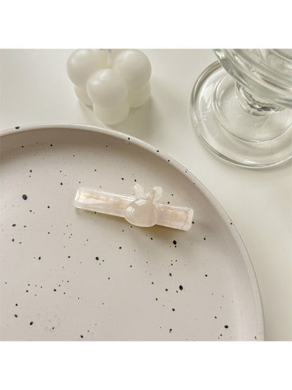 Beau hair clip placed on wooden surface with natural light highlighting colors