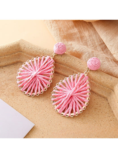 Earedge raffia teardrop earrings styled with summer accessories on a table