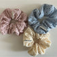Scrunchie wrapped around a hand showing stretch and fabric detail