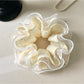 Side view of Gifty printed scrunchie highlighting ruffled design and elastic band