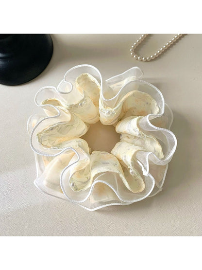 Side view of Gifty printed scrunchie highlighting ruffled design and elastic band