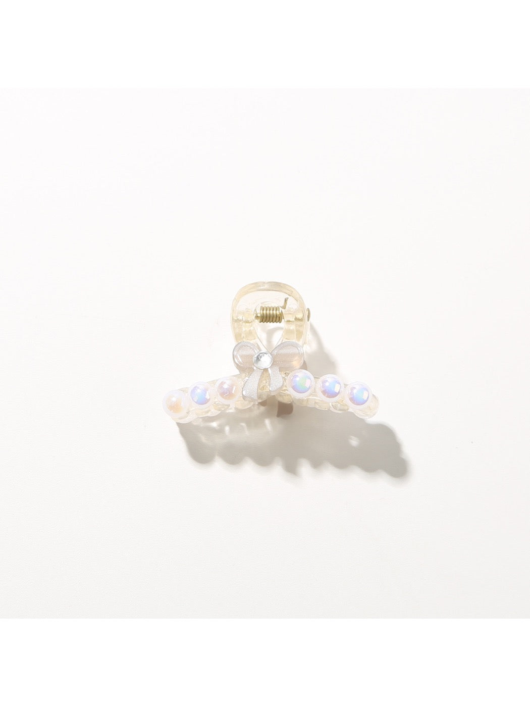 Bright multi color hair clip held near face to show scale