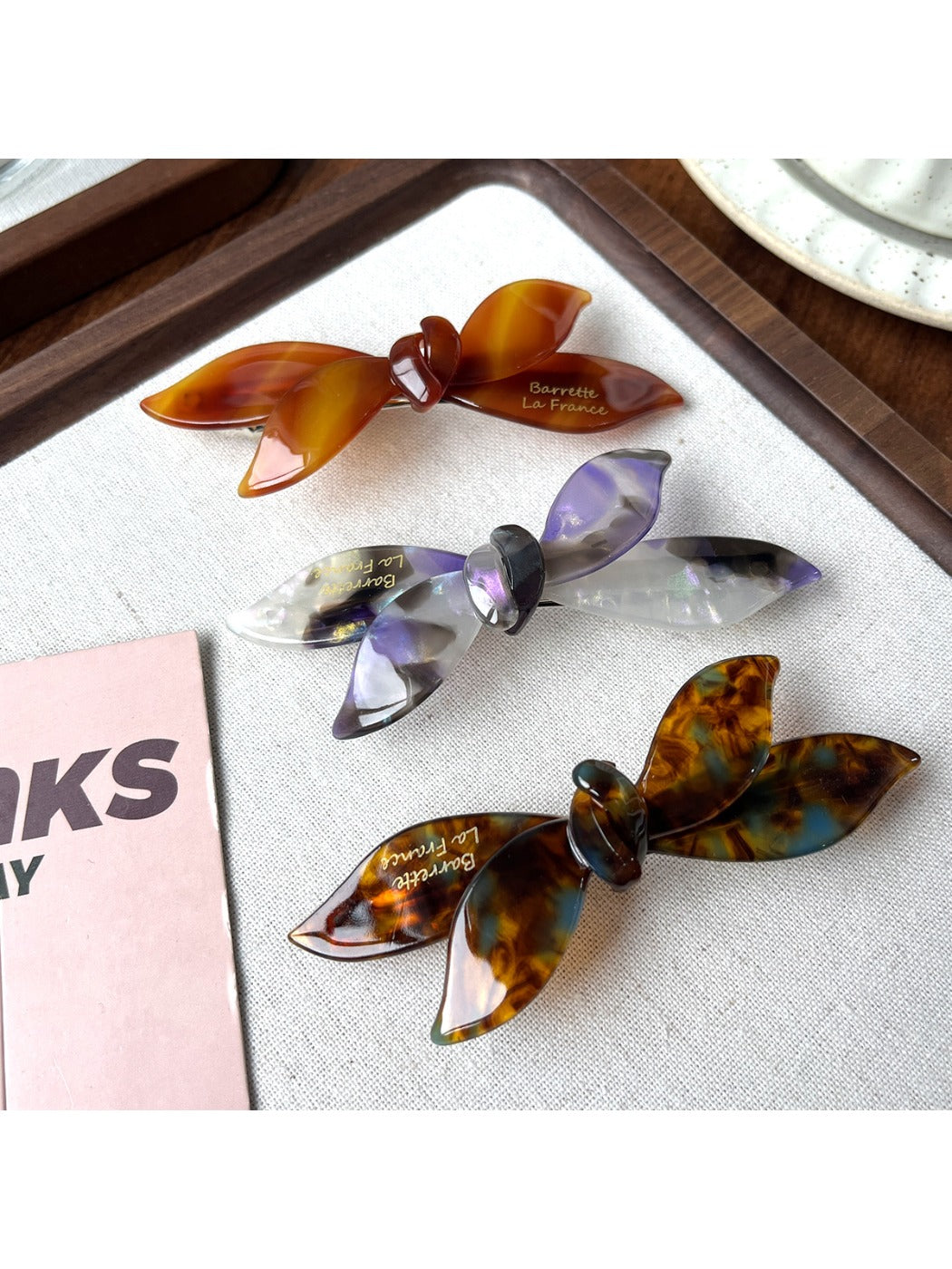 Beau bow shaped updo hair clip held in hand displaying size and shape