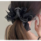 Gifty dark large bow scrunchie styled in a ponytail on a model