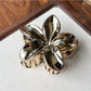 Beau flower shaped claw clip photographed with soft natural lighting