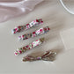 Close-up of Beau hair clip with detailed floral pattern in soft pastel colors