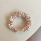 Pink mini scrunchie styled on a wrist as a bracelet accessory