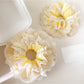 Close-up of yellow lace scrunchie showing delicate fabric texture