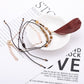 Lovra small bead bracelet with feather pendant laid flat on wooden surface