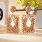Earedge raffia wrapped square earrings displayed against a neutral fabric background