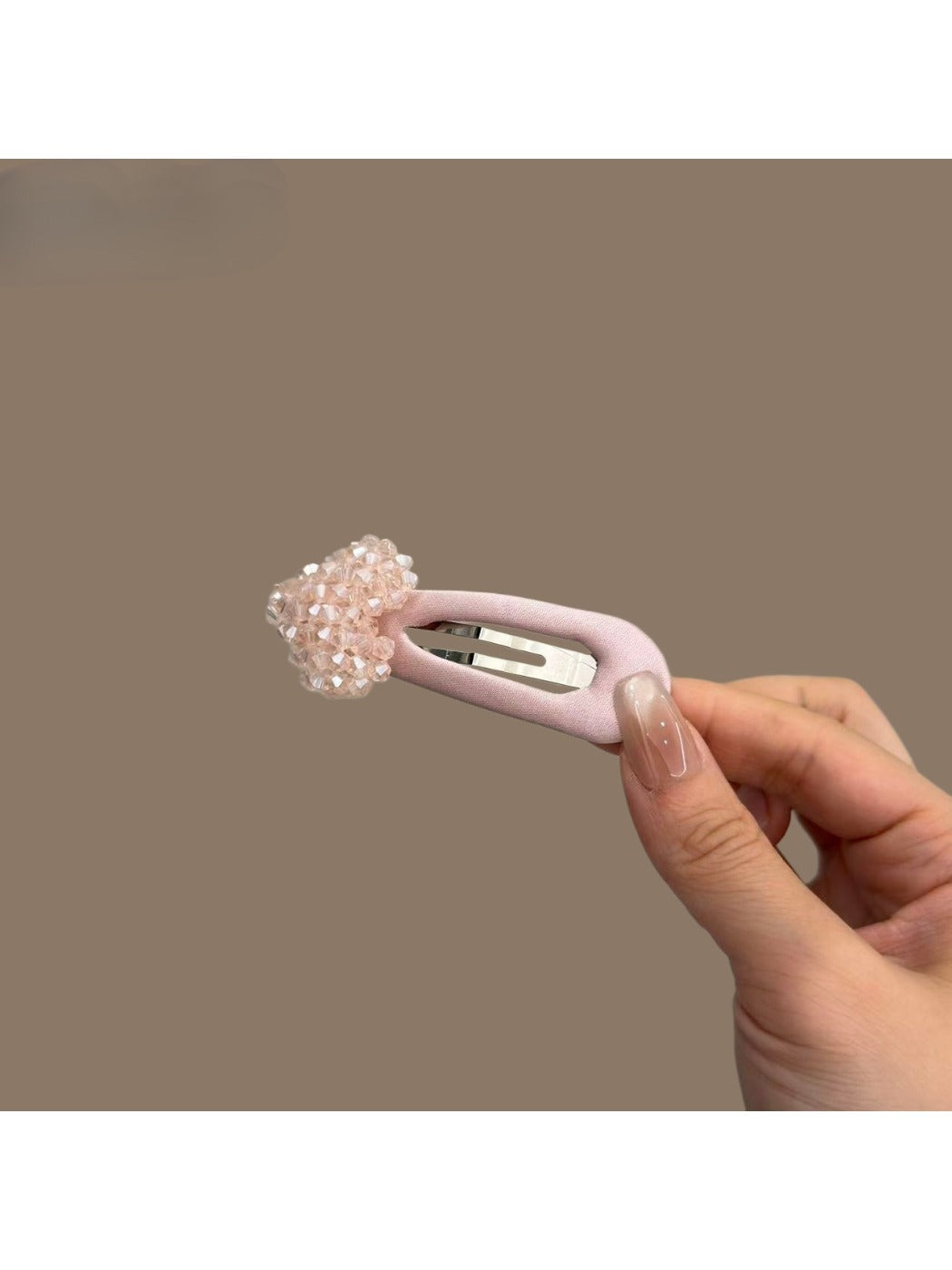 Pink heart-shaped hair clip attached to brown hair