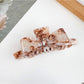 Beau bow shaped claw clip in soft pink color with smooth edges