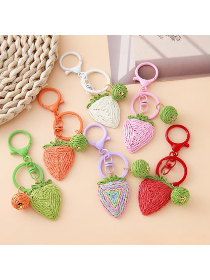 Close-up of a cute strawberry charm keychain with green leaves and red seeds