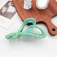 Beau ombre heart shaped bow claw clip shown clipped into curly hair on a model