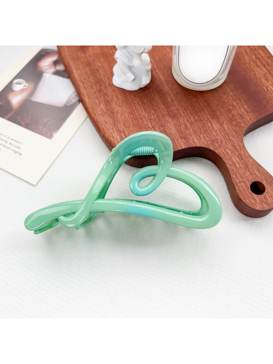 Beau ombre heart shaped bow claw clip shown clipped into curly hair on a model