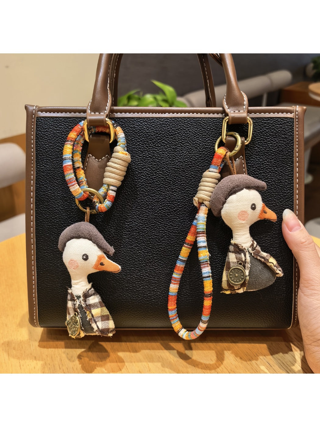 Close-up of a stylish duck charm keychain with gold-tone metal and enamel details