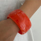 Lovra wide round bangle bracelet photographed with soft focus background for contrast