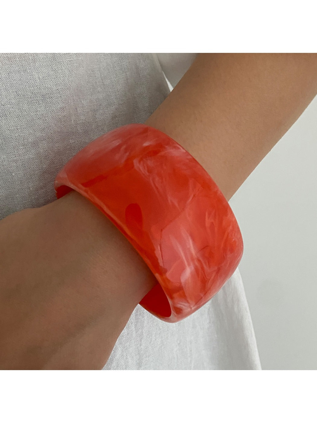 Lovra wide round bangle bracelet photographed with soft focus background for contrast