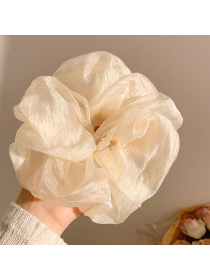 Gifty scrunchie laid flat highlighting its gentle fabric and simple design
