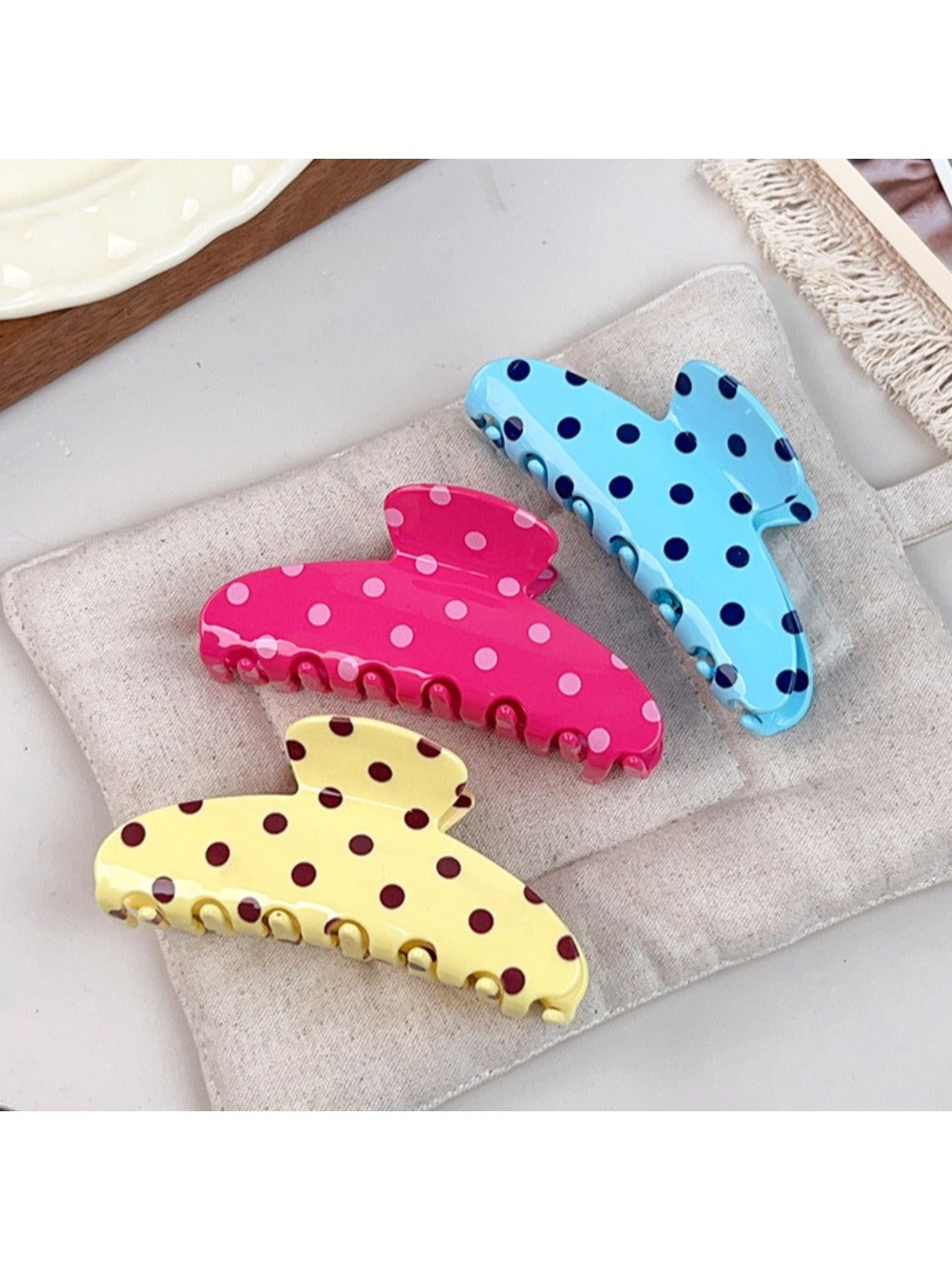 Beau polka dot half circle claw clip held in hand for size reference