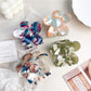 Close-up of colorful flower hair claw clip showing petal details and clasp mechanism