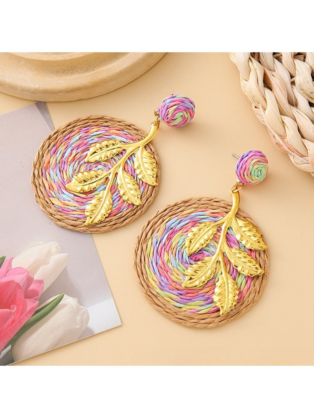 Pair of Earedge round leaf pendant earrings hanging on a jewelry stand