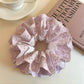 Close-up of purple fabric double scrunchie showing cutout details