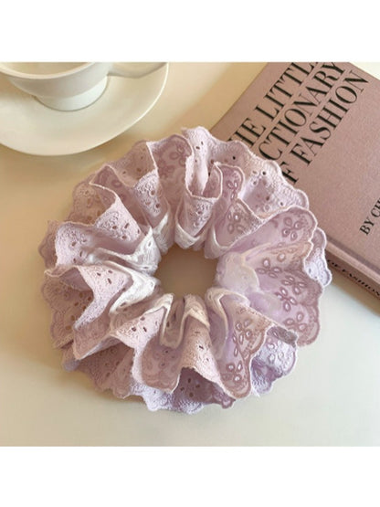 Close-up of purple fabric double scrunchie showing cutout details