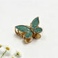 Beau butterfly hair clip in pastel blue displayed on a wooden surface