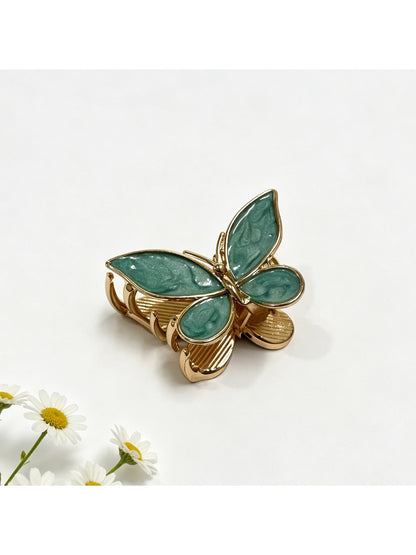 Beau butterfly hair clip in pastel blue displayed on a wooden surface